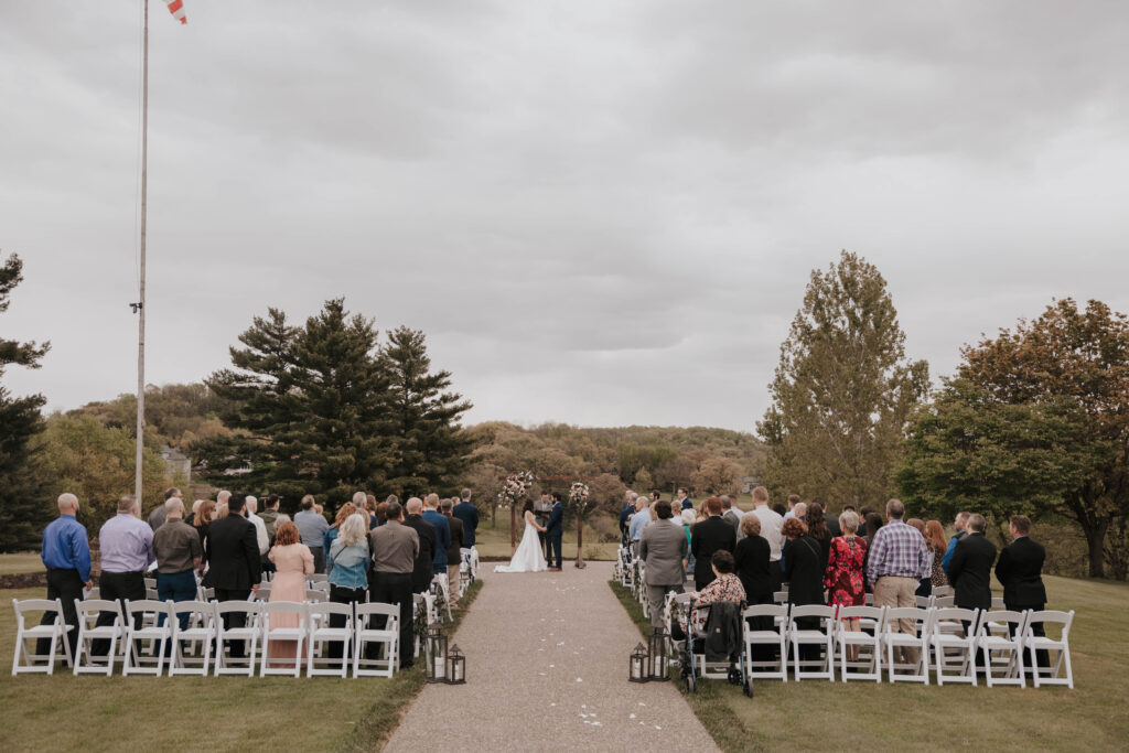 Guests experience an outdoor wedding ceremony