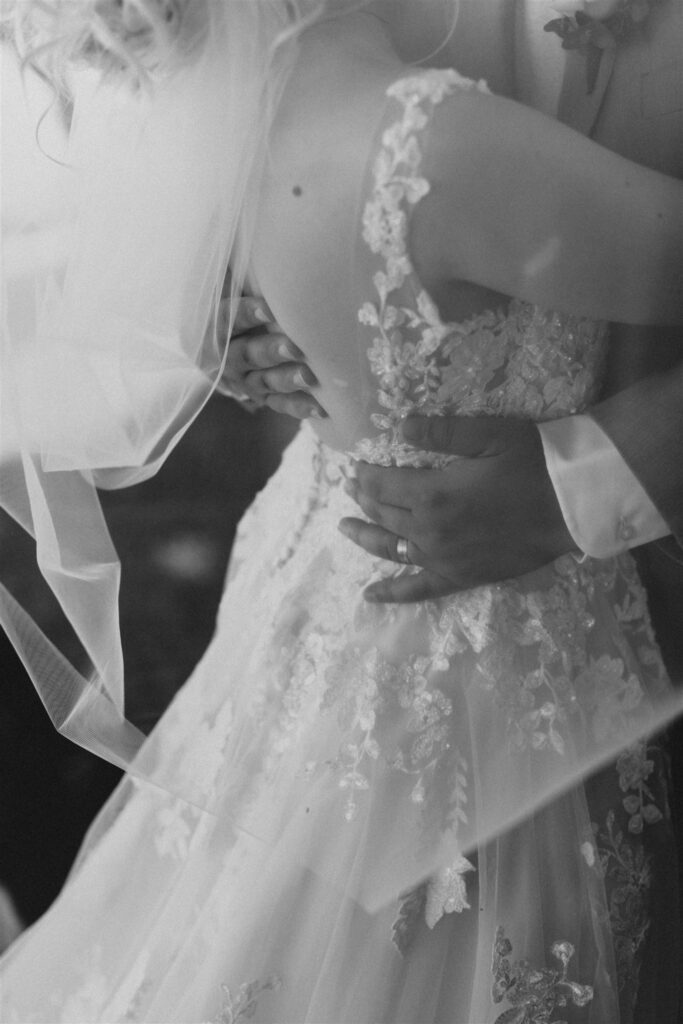 Black and white photo of a bride and groom embracing